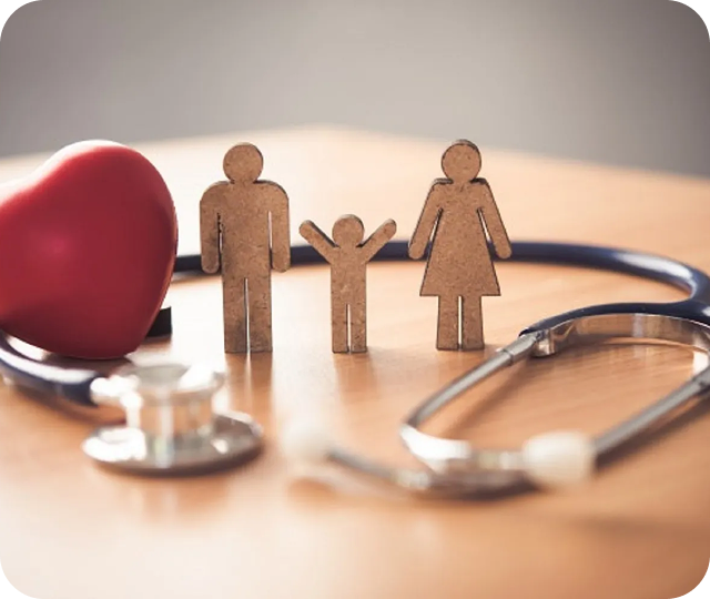 A wooden family figure with a stethoscope and a heart model on a table